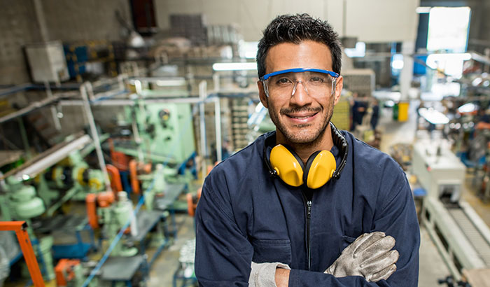 Latin American man working at a metal factory and wearing protective wear