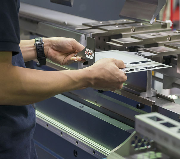 The technician operator working with press brake hydraulic bending machine. The sheet metal working operation by skill operator.