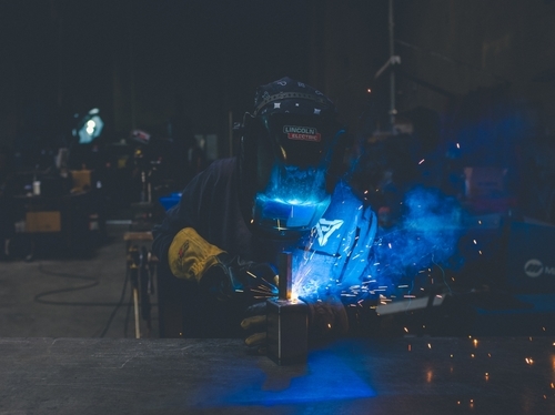 masked metal worker in darkness