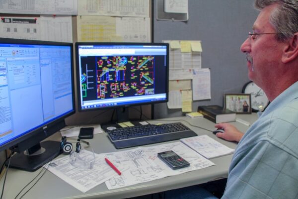 dual monitor engineer working in cubicle