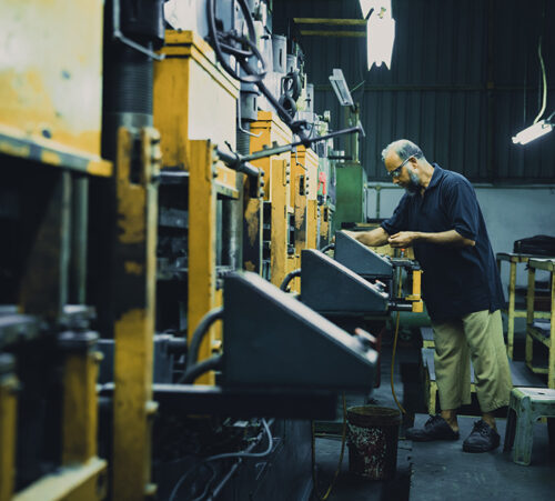 View of a lone factory member staying late into the night to ensure the production is complete.