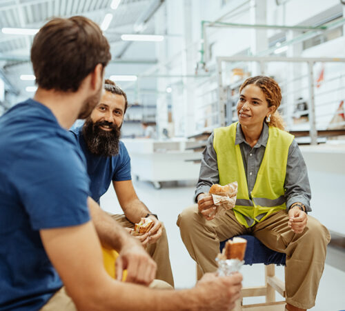 Teamwork in industry, employees eating breakfast