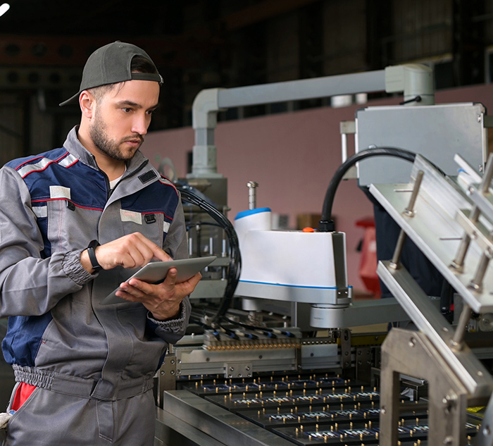 A young worker in a battery factory monitors the process