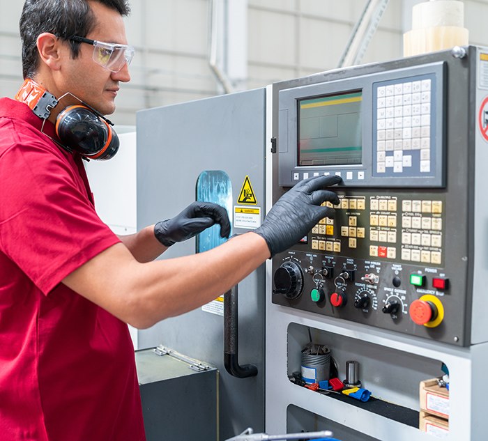 Machinist operating manufacturing machine
