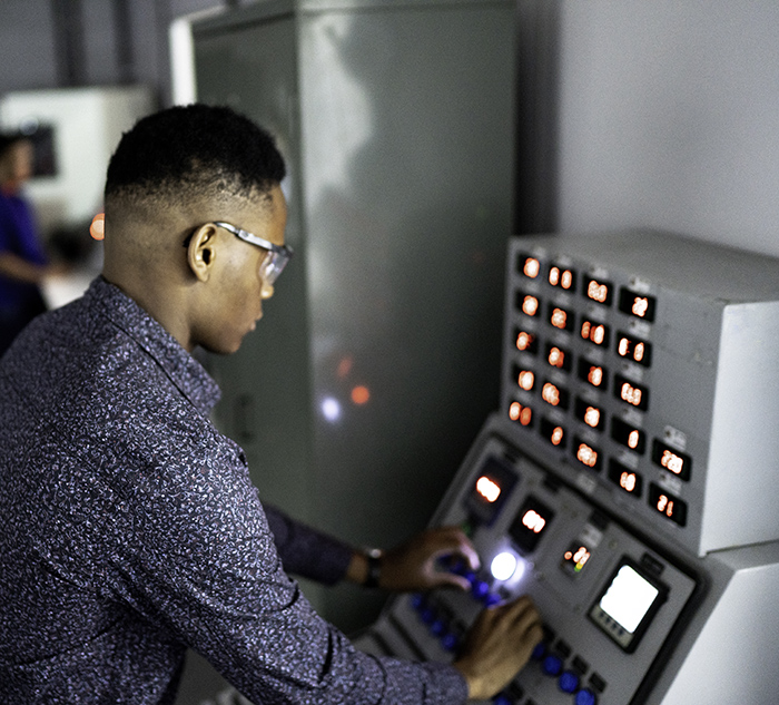 Young employee working and using machine in industry