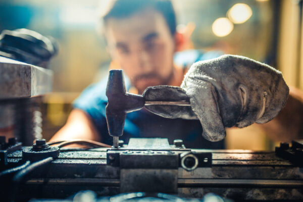 Worker Installing Tool on Machine in Factory