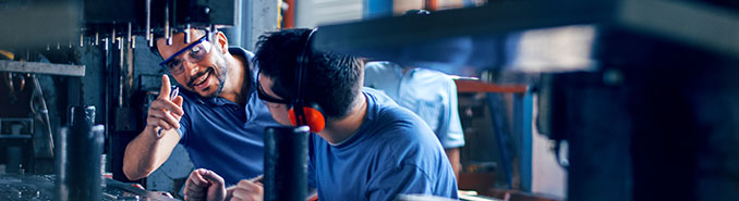 Workers working on the machine for cutting metal sheets