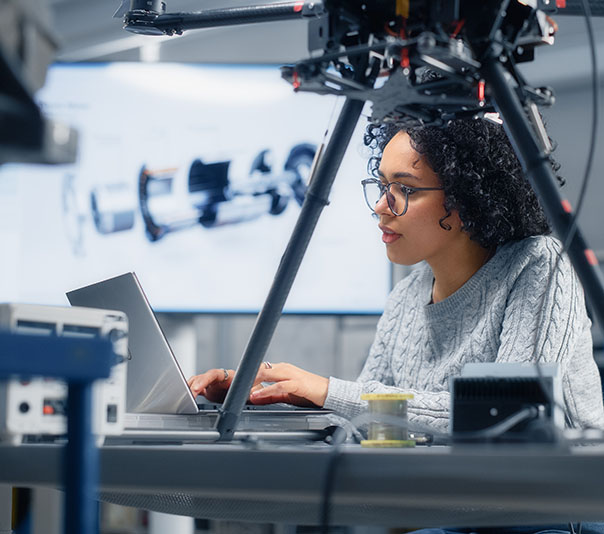 Concentrated Black Female Engineer Writing Code. Developing Software for Drone Control in the Research Center Laboratory. Technological Breakthrough in Flight Industries Concept.