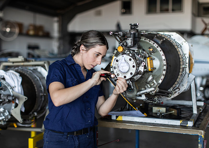 Real life young female aircraft engineer apprentice at work