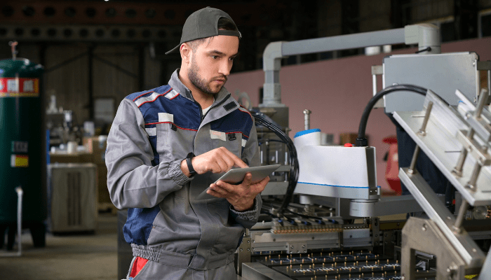 Un fabricant travaillant avec un iPad sur le plancher de production