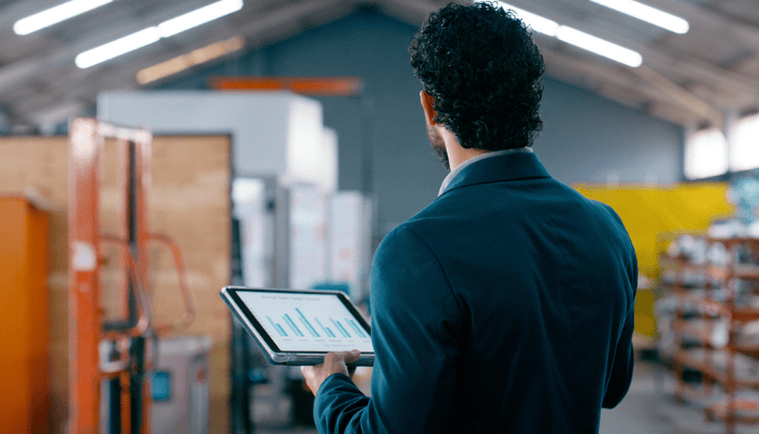A manufacturer working on the shop floor using a tablet