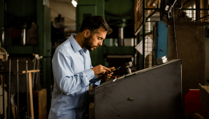 A manufacturer working on the shop floor using a tablet.