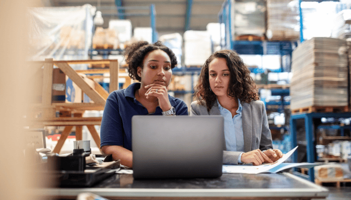 Two manufacturers working on the shop floor using a laptop